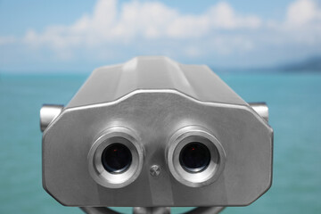 Metal tower viewer installed near sea, closeup. Mounted binoculars