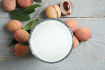 Obraz na płótnie Canvas Fresh lychee juice and fruits on grey wooden table, flat lay