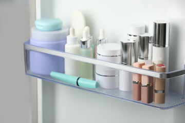 Different cosmetic products on shelf in refrigerator