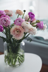 Bouquet of beautiful ranunculuses on table in bedroom