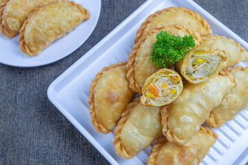 pastel goreng isi bihun, a snack containing vermicelli noodles and vegetables cooked by frying. It has a crunchy and savory texture. pastels are easy to find in Indonesian traditional markets