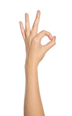 Woman showing okay gesture on white background, closeup of hand
