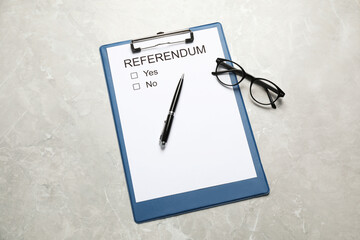 Referendum ballot with clipboard, glasses and pen on light grey marble table, flat lay