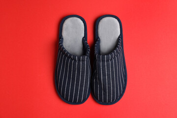 Pair of stylish slippers on red background, top view