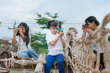 Children kids exploring nature through magnifying glass and binoculars on outdoor playground. The child explores the world through a magnifying glass and binoculars .