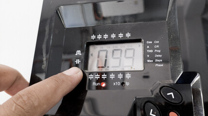 The electrician Checking Power Factor regulator computer max 12 steep circutor.