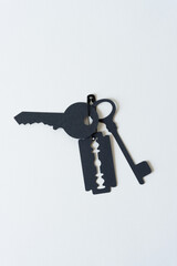 paper silhouette of a razor blade (glyph or dingbat) and keys joined together with a metal safety pin