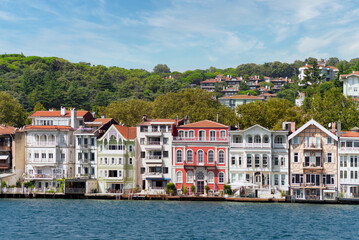 Fototapeta na wymiar View from the sea of the green mountains of the asian side of Bosphorus strait, with traditional houses and dense trees in a summer day