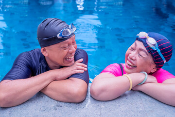 Elderly couple chatting together on swimming pool
