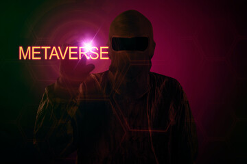 Hooded hacker touch metaverse word in cyberspace