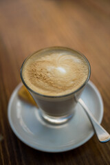 Coffee time- Creamy Cafe latte isolated on wooden table