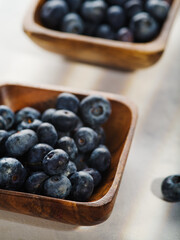 Close-up. Blueberries in wooden bowls on a white background. Delicious healthy product, ready to eat. Vitamins, antioxidants. Healthy lifestyle. Cooking.