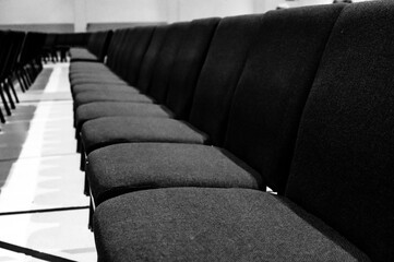 Obraz premium selective focus on a padded seat cushion of a row of chairs in a auditorium. 