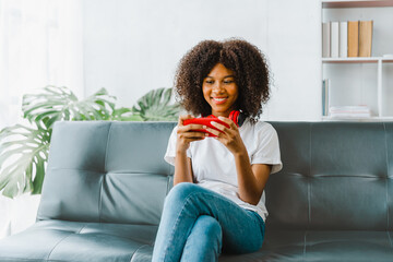 Excited cheerful gen Z female using mobile phone getting surprising good news while playing mobile...