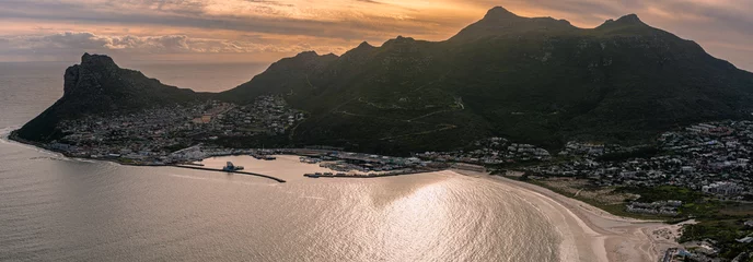 Foto auf Leinwand Sun setting behind the Sentinel Peak in Hout Bay, Cape Town © Mike