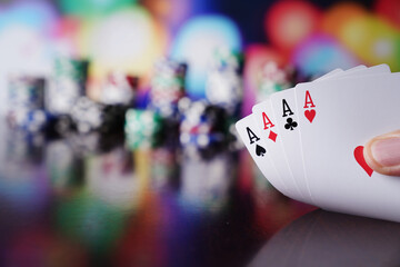 Casino theme.  Gambling games. Dices, cards and poker chips on a colorful bokeh background.