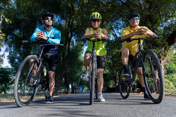 Fototapeta premium Confident cyclists leaning on handlebar of bicycle amidst forest 