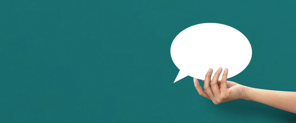 Hand holding shape of speech bubble icon on blue background.