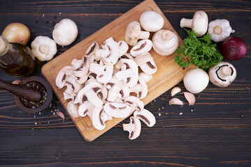 sliced raw champignon mushrooms on wooden cutting board