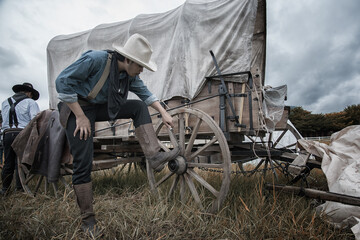 Portrait  young cowboys in hand hold Cowboy knife lean wagon, concept in farm.