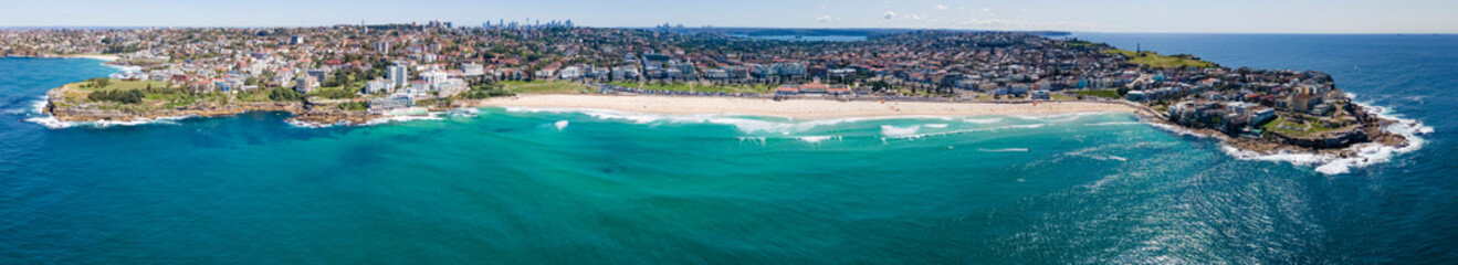 Panoramic aerial drone view of iconic Bondi Beach in Sydney, Australia looking west toward Sydney...