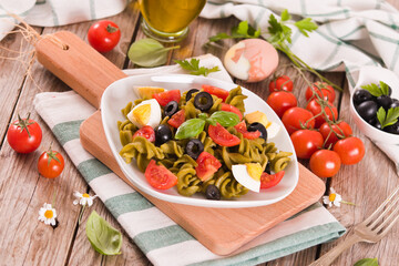 Fusilli pasta with cherry tomatoes, eggs and black olives.