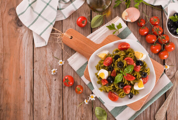 Fusilli pasta with cherry tomatoes, eggs and black olives.