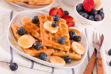 Waffles with blueberries, bananas and honey.