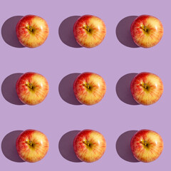 Seamless pattern with fresh apple on purple background.