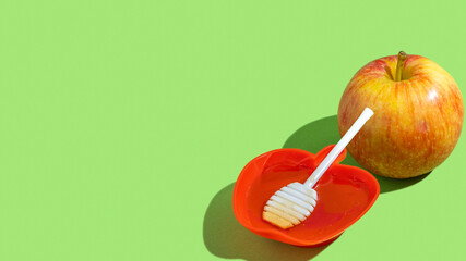 Fresh honey and apple fruit for Jewish holiday Rosh Hashanah on green background with copy space.