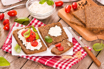 Rye bread with cottage cheese, basil and tomato.
