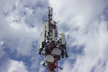 Antenna mast with white clouds in the background
