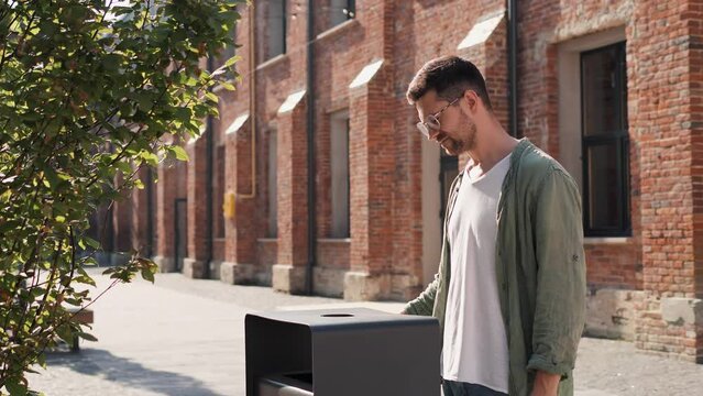 Stop no smoking, Pensive freelancer businessman in casual outfit, glasses throws electronic cigarette into a trash then looking to camera outdoors. The young man quit smoking for his good health. 