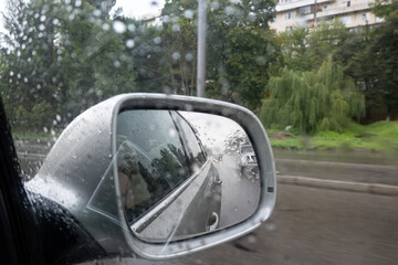 bad weather, rainy day, rain drops on car side mirror, filming on the way, raining on the street