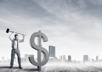 Determined banker man against modern cityscape breaking dollar concrete figure