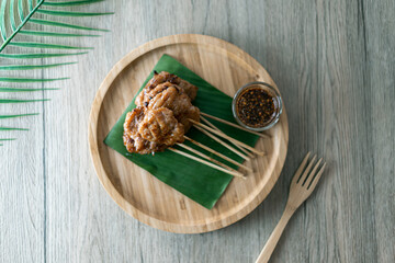 Top view of grilled pork or Moo Ping with spicy dipping sauce street food in Thailand