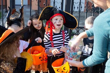 Woman giving treats to children in costumes