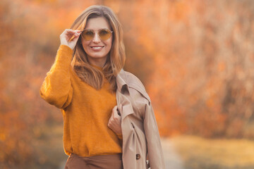 Closeup portrait of happy and smiling caucasian woman 30-35 years old in fashion fall outfit...