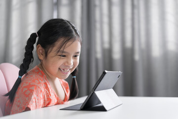 asian child back to school and smile study online class on computer tablet or kid girl student...