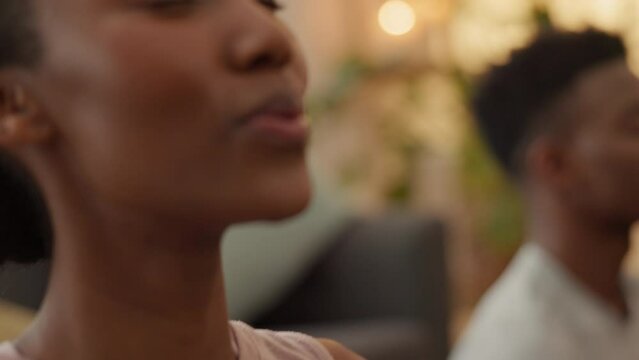 Black couple, bond or meditation breathing in mental health, chakra energy or mind training in living room or house interior. Zen yoga, peace or relax man and woman in holistic lotus fitness wellness