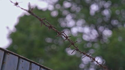 Security Fence Made with Sharp Rusty Barb Wire Wrapped around Metal Rebar Rod