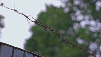 Security Fence Made with Sharp Rusty Barb Wire Wrapped around Metal Rebar Rod