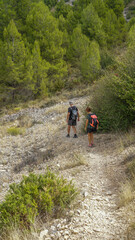 Senderistas irreconocibles de ruta por una senda de piedras en una ladera de montaña