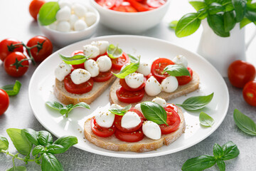 Caprese toasts with mini mozzarella cheese, cherry tomato and basil