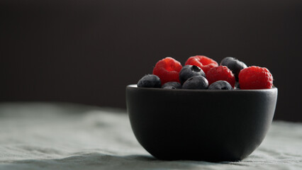 Fresh berries in bowl on linen napkin