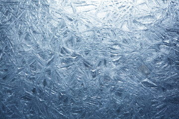 The texture of the ice surface. Winter background, festive background in the form of ice crystals, in natural deep blue color.