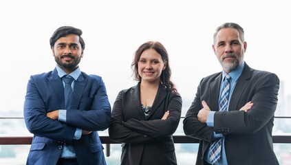 Portrait photo of a team of asian and caucasian businessmen and businesswoman holding up to themselves in a professional pose and gesture