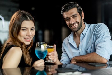 Portrait photo of a couple having a good time together drinking cocktail in a sky lounge and bar in Bangkok city
