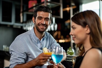 Portrait photo of a couple having a good time together drinking cocktail in a sky lounge and bar in Bangkok city