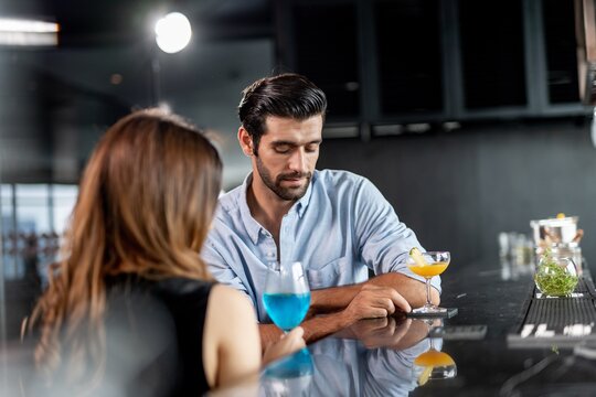 Portrait photo of a couple having a good time together drinking cocktail in a sky lounge and bar in Bangkok city - Powered by Adobe